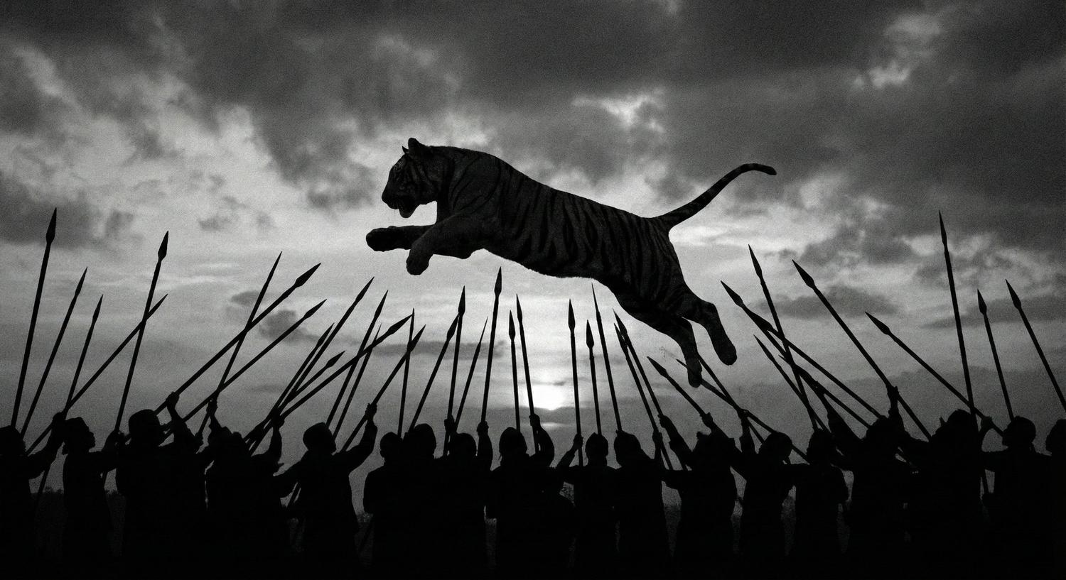 Siluet harimau melompat di atas kerumunan orang yang mengacungkan tombak ke arah langit saat matahari terbenam.